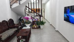 a hallway with a couch and a table with flowers at Home 1/31 Nhà Chung Đà Lạt in Da Lat