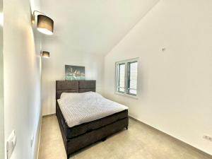 une petite chambre avec un lit et une fenêtre dans l'établissement Seaside Apartments Zlokovic, à Herceg-Novi