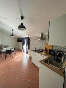 een keuken met een wastafel en een tafel met stoelen bij beb dragonara apartment in Torre Maggiore