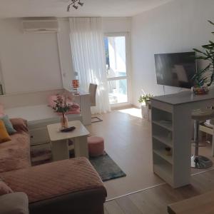 a living room with a couch and a flat screen tv at VJEKA HOME in Ploče