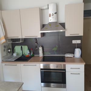 a kitchen with white cabinets and a stove top oven at VJEKA HOME in Ploče