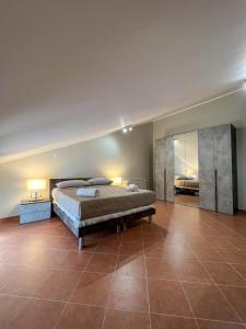 een grote slaapkamer met een bed en een tegelvloer bij beb dragonara apartment in Torre Maggiore