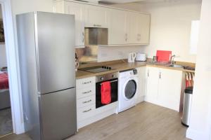 a kitchen with a refrigerator and a washing machine at Central Shaftesbury with private parking in Shaftesbury