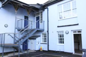 a white building with a staircase and a door at Central Shaftesbury with private parking in Shaftesbury