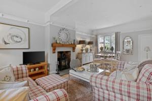 a living room with two couches and a tv at Rosemary Cottage in Leicester