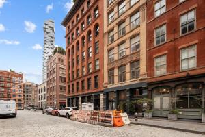 Tribeca Loft Vanderbilt by RoveTravel في نيويورك: شارع المدينة ومباني الطوب الطويلة والسيارات