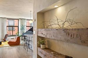 Tribeca Loft Vanderbilt by RoveTravel في نيويورك: غرفة معيشة وغرفة طعام بجدار من الطوب
