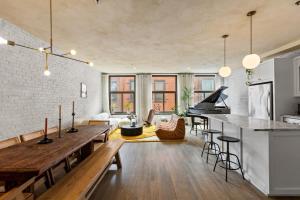 Tribeca Loft Vanderbilt by RoveTravel في نيويورك: مطبخ مفتوح وغرفة معيشة مع بيانو