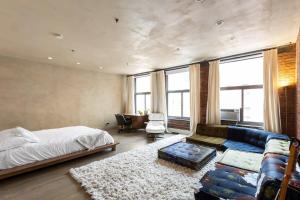 a bedroom with a bed and a blue couch at Tribeca Loft Vanderbilt by RoveTravel in New York