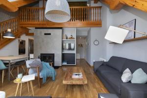a living room with a couch and a table at Ático de Pao by BeValle in Panticosa