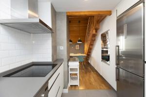a kitchen with a stainless steel refrigerator and white walls at Ático de Pao by BeValle in Panticosa +25 photos