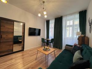 a living room with a green couch and a table at Apartament w centrum Jeleniej Góry przy ulicy Długiej in Jelenia Góra