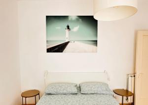 sypialnia z łóżkiem i zdjęciem latarni morskiej w obiekcie MareSole Apartment w mieście Lido di Ostia