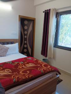 a bedroom with a bed and a window at Sadhna Holiday Home in Bhowāli