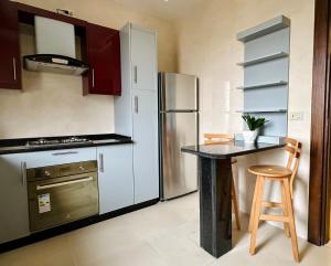 a kitchen with a stainless steel refrigerator and a table at Luxury Abdoun apartment in Amman