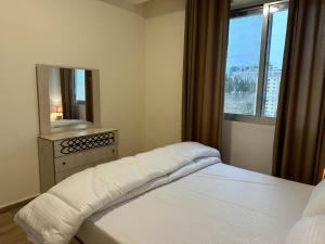 una camera da letto con un letto con specchio e una finestra di Luxury Abdoun apartment ad Amman