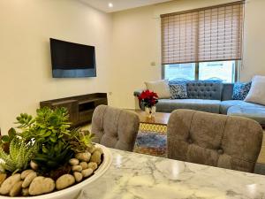 a living room with a table and chairs and a couch at Luxury Abdoun apartment in Amman