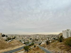 a view of a city with a road and buildings at Luxury Abdoun apartment in Amman