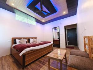 a bedroom with a bed with a ceiling fan at Sadhna Holiday Home in Bhowāli