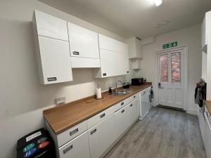 a kitchen with white cabinets and a sink at Ashbrook Stert St 5 bedroom property in Abingdon