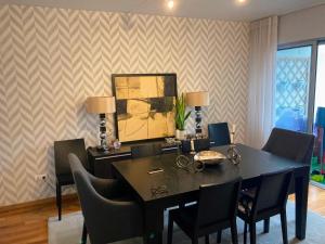 ein Esszimmer mit einem schwarzen Tisch und Stühlen in der Unterkunft Oliveira House in Ponta Delgada