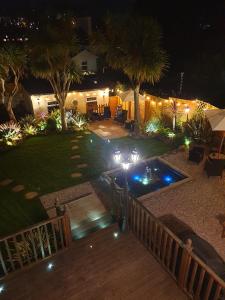 a backyard at night with a pool and lights at Appletorre House Holiday Flats in Torquay