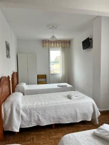 1 Schlafzimmer mit 3 Betten und einem Fenster in der Unterkunft Hostería Somo in Somo