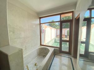 a bath tub in a room with a window at Buena Vista Luxury Garden Spa Resort in Jaipur