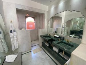 a bathroom with a sink and a large mirror at Buena Vista Luxury Garden Spa Resort in Jaipur