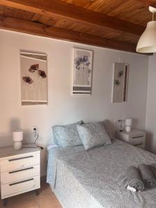 - une chambre avec un lit et des photos sur le mur dans l'établissement La Terraza de Consolación 17, à Cáceres