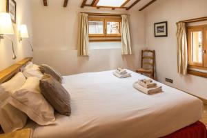 a bedroom with a large white bed with towels on it at Chalet Grand Cru in Chamonix-Mont-Blanc