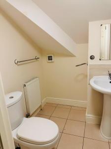 a bathroom with a toilet and a sink at Elm Vale Lodge in Liverpool