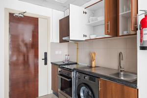 a kitchen with a washing machine and a sink at Silkhaus Elegant Studio Near Silicon Central Mall in Dubai