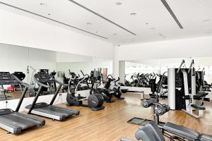 ein Fitnessstudio mit vielen Laufbändern und Kardiogeräten in der Unterkunft Silkhaus Elegant Studio Near Silicon Central Mall in Dubai