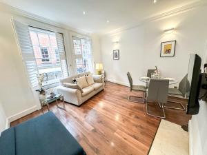 a living room with a couch and a table at Alluring 2-Bed, 2-Bath Flat on High Street Kensington, Near Kensington Palace in London