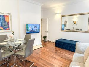 a living room with a table and a couch at Alluring 2-Bed, 2-Bath Flat on High Street Kensington, Near Kensington Palace in London