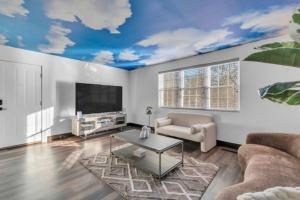 Una sala de estar con un sofá y un televisor. en Roland park Customized Apartment, en Baltimore