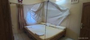 a room with a hanging bed with white sheets and pillows at Ya-Penda in Ndangane