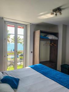 a bedroom with a bed with a view of the ocean at Hotel Flots d'Azur in Nice