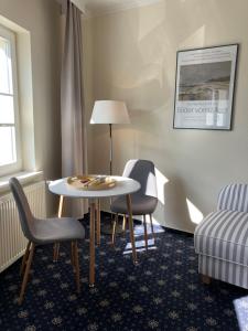 a room with a table and two chairs and a bed at Villa Dorothea in Heringsdorf