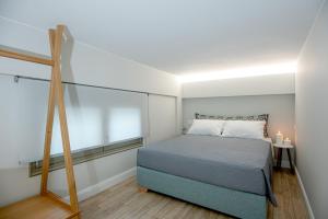 een slaapkamer met een bed, een raam en een ladder bij Mylos Modern Apartments,By Idealstay Experience in Agios Nikolaos
