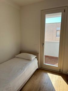 a bedroom with a bed and a large window at Appartamento Parini in Porto San Giorgio