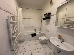 a white bathroom with a toilet and a sink at Deutscher Hof in Plauen