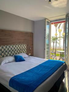 een slaapkamer met een groot bed en een balkon bij Hotel Flots d'Azur in Nice