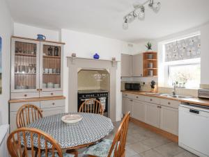 a kitchen with a table and chairs and an oven at Amelie Cottage in Beaumaris
