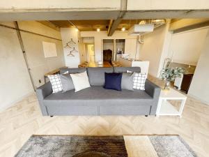a living room with a gray couch with pillows at b hotel Dai3Himawari - Up to 10p 1 min Peace Park, Wonderful huge house in Hiroshima