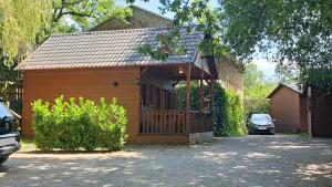 a small wooden house with a car parked in the driveway at Càmping Els Roures in Camprodon