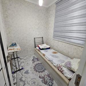 a small bedroom with a bed and a table at 2-х комнатная квартира in Tashkent