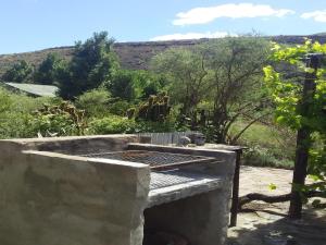 an outdoor grill with a view of a mountain at Starry Nights Guest House in Nieu-Bethesda