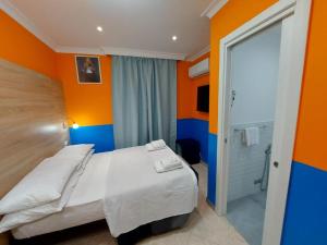 a bedroom with orange and blue walls and a bed at Hotel Positano Suite in Rome